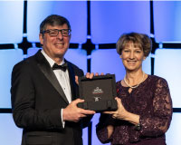 Eileen Collins (right) presents the OMEGA speedmaster watch to Christopher Scolese