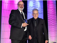 Rob Navias (right), 2017 Space Communicator winner, presents the 2020/2022 Space Communicator trophy to photographer Bill Ingalls (left).